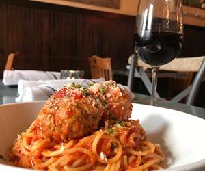 Spaghetti and Meatballs, accompanied by a glass of wine