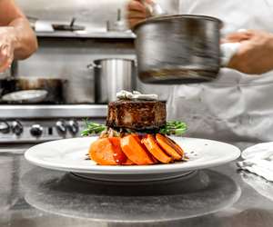 Plating a filet mignon main course in the kitchen